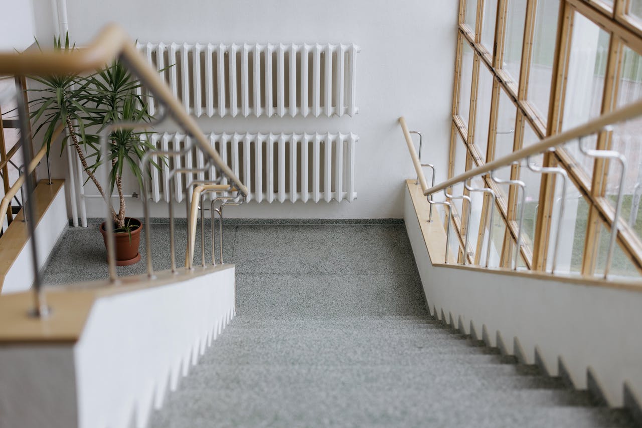 A sleek indoor stairway with modern railings and large windows, offering a minimalist design.